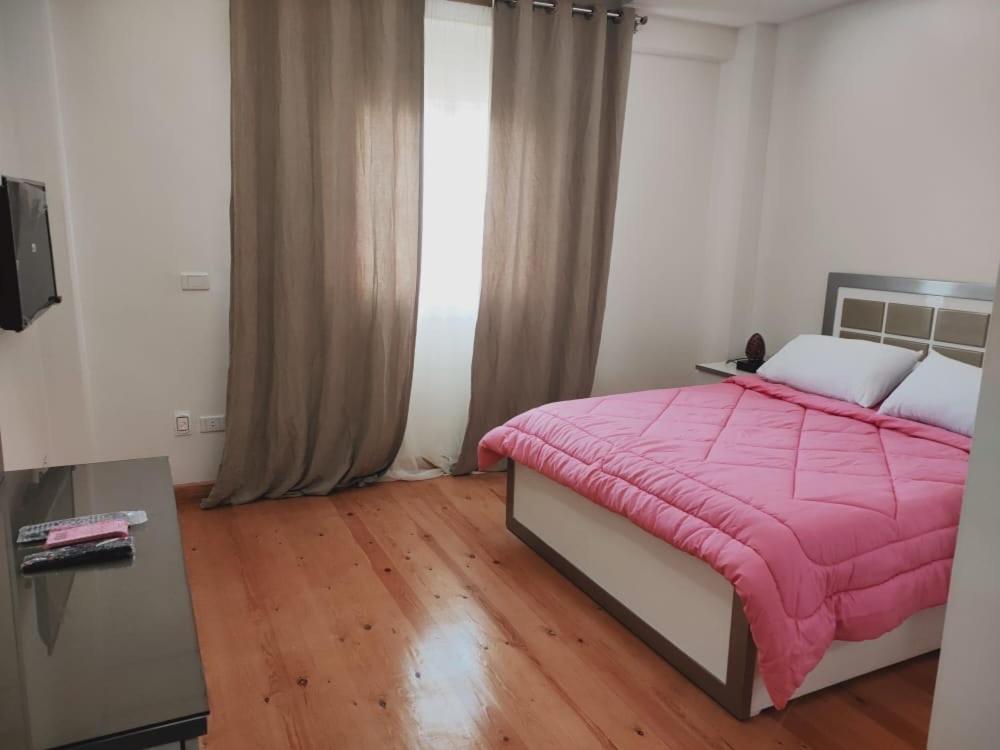 开罗Ramco For Furnished Apartments And Accommodation Compound Leila的卧室配有粉红色毯子,位于床上