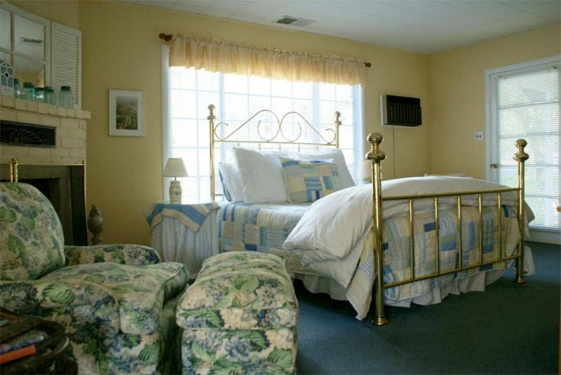 卡利斯托加Trailside Inn Bed and Breakfast的一间卧室配有一张床、一张沙发和一把椅子