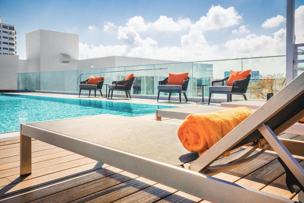 迈阿密海滩Berkeley Park MGallery Hotel Collection的一座带椅子的建筑屋顶上的游泳池