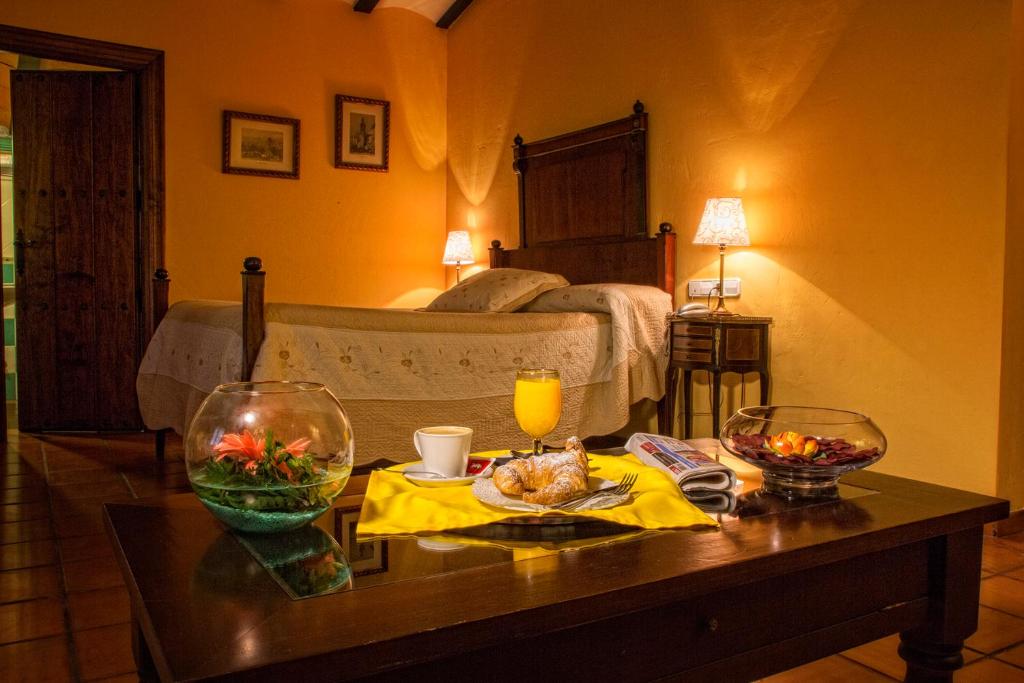 Casas de los Pinos博得加拉文塔酒店的一间房间,配有一张床和一张桌子,上面有食物