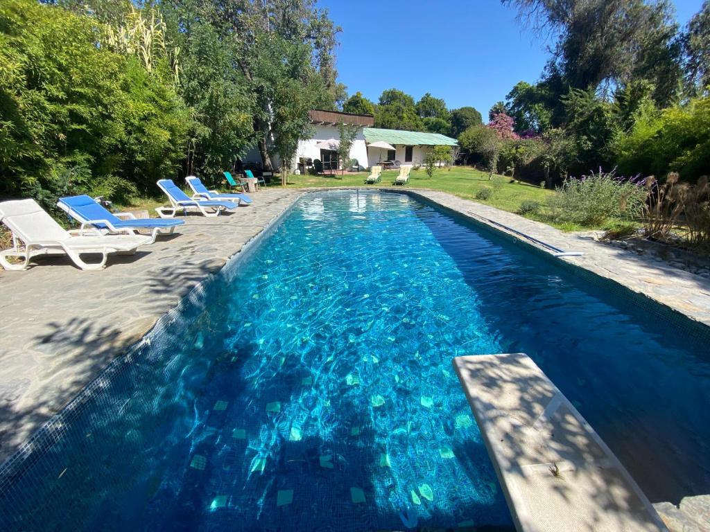 TalaganteThe White House - El Monte RM的一个带蓝色海水和躺椅的游泳池