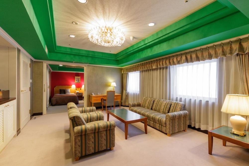 福岛吨详福岛旅馆的酒店客房带绿色的天花板以及起居室