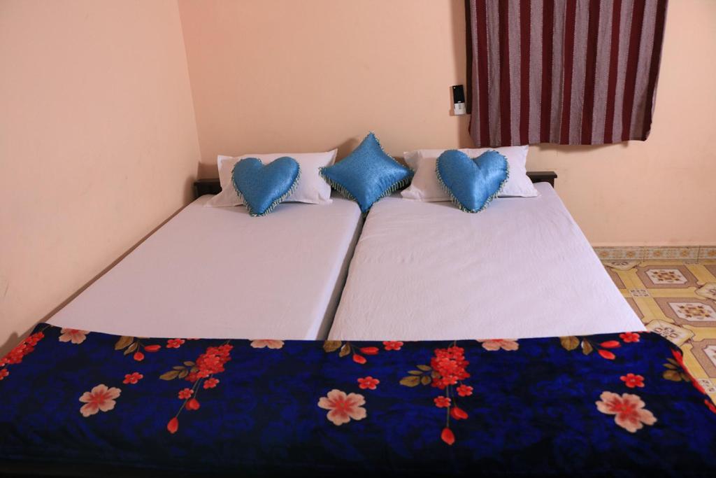 蓬蒂切里Paradise corner的一间卧室配有两张带蓝色枕头的床