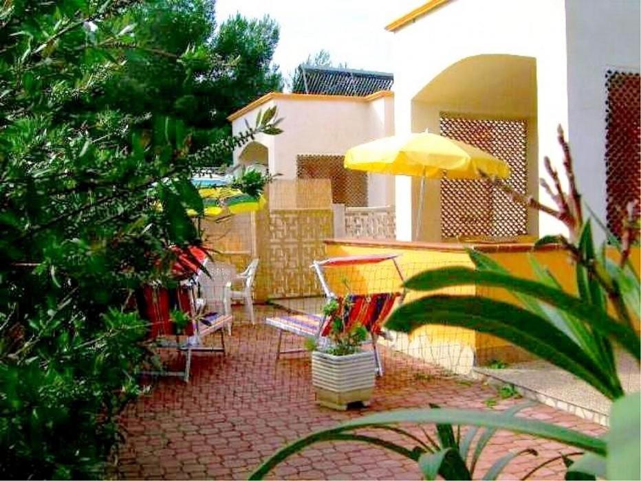 维耶斯泰Villa Carla的庭院配有椅子和黄色雨伞