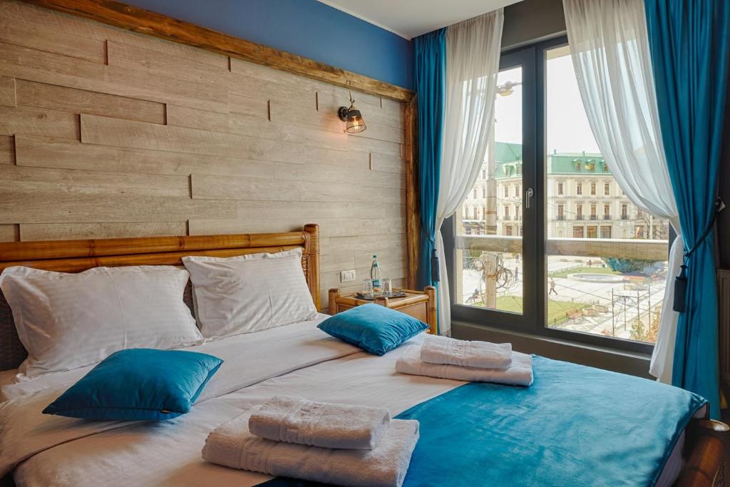 雅西Piata Unirii Central Apartments的一间卧室配有一张带蓝色枕头的大床和窗户。