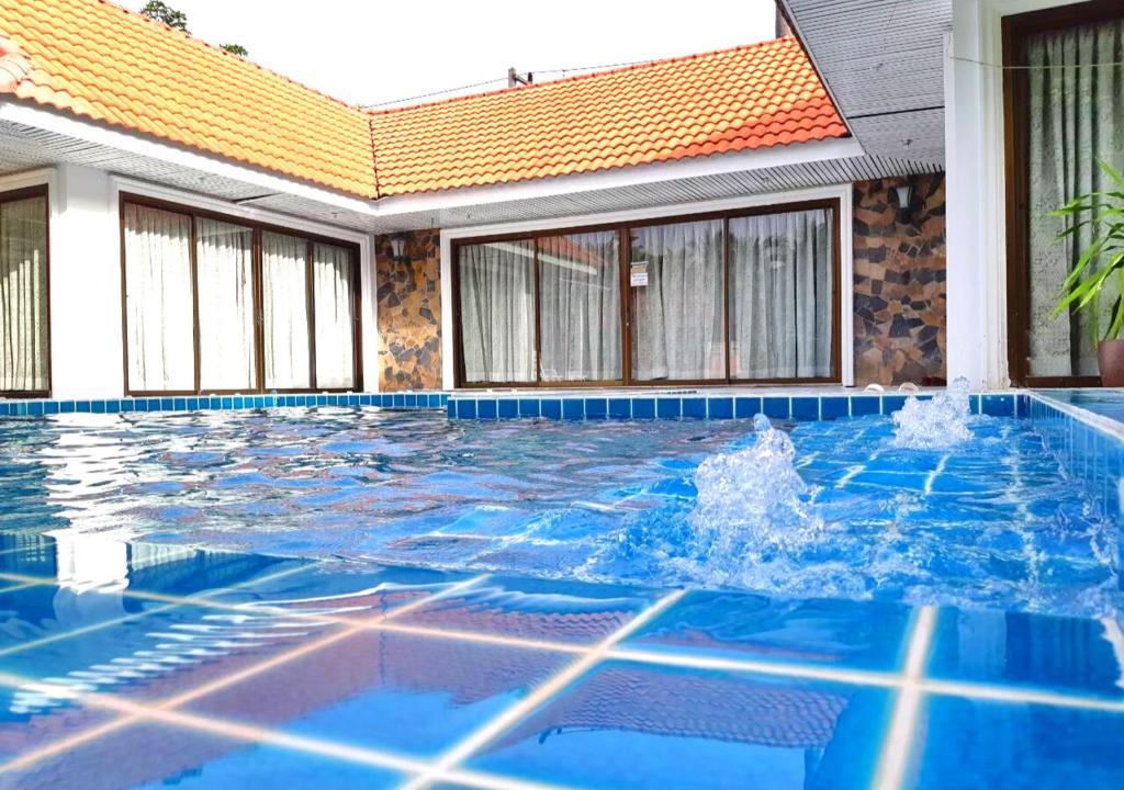 三百岭Baan Golden Pool Villa的大楼前的蓝色海水游泳池