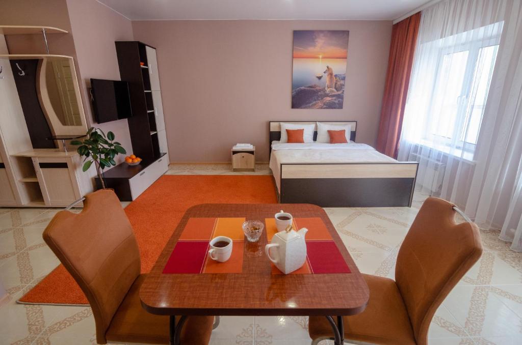 伊尔库茨克Апарт-отель МОДНЫЙ的客厅配有桌子和床。
