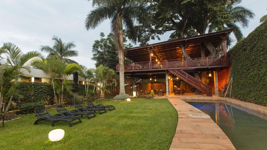 坎帕拉Humura Resorts的一座带游泳池和一些椅子的房子