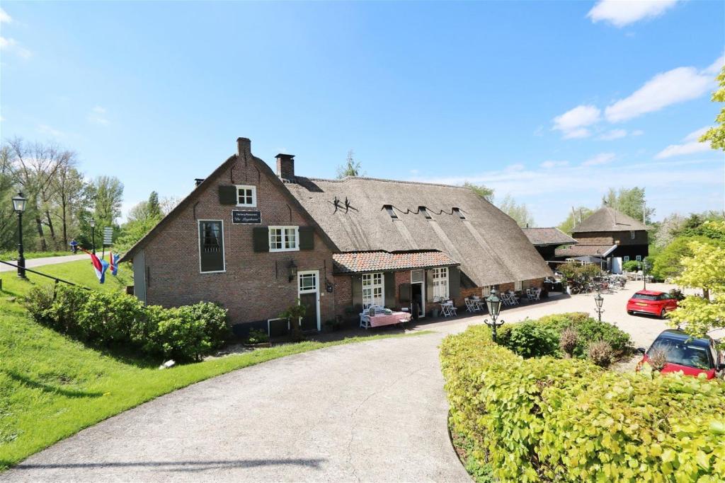 OosterwijkHerberg de Lingehoeve的茅草屋顶和车道的古老房屋