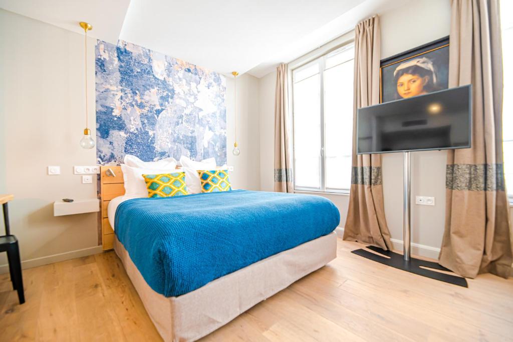 巴黎Residence Les Boulevards的一间卧室配有一张床和一台平面电视