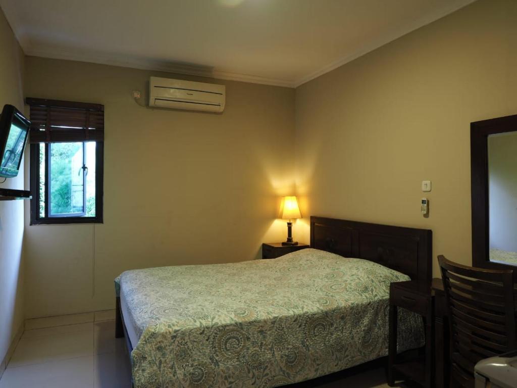 雅加达Rhiz Guest House Tebet的一间卧室配有床、灯和窗户