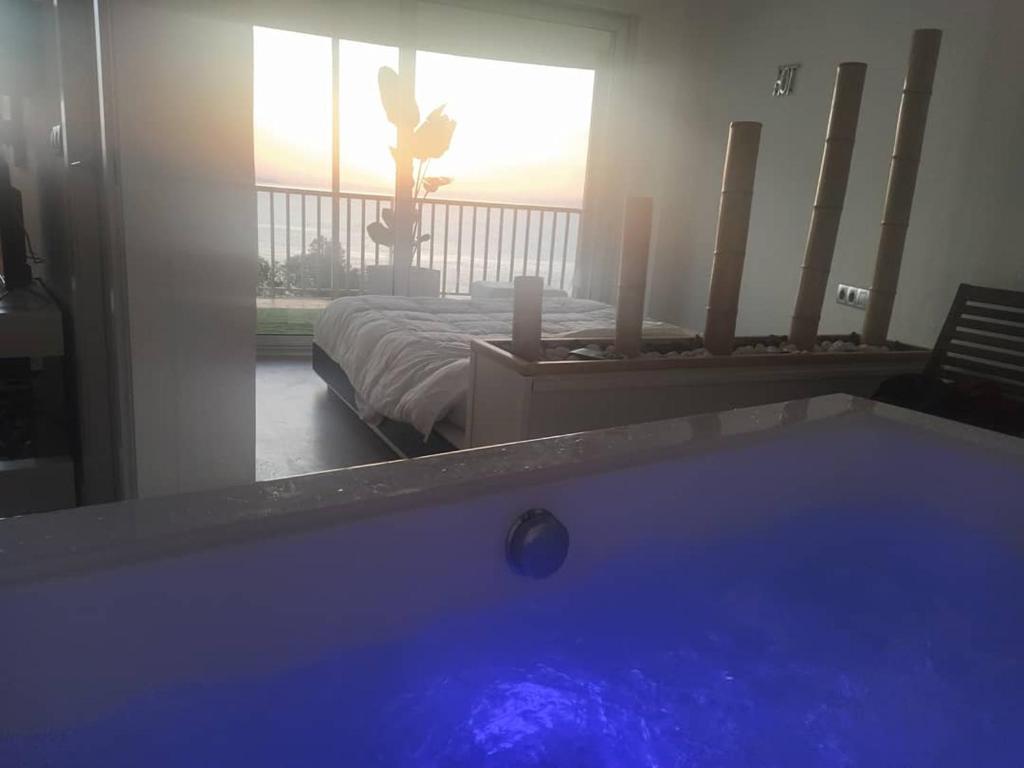 迈阿密普拉特亚Exclusivo Apartamento Spa privado frente el mar的床上的浴缸,窗户上的人的浴缸
