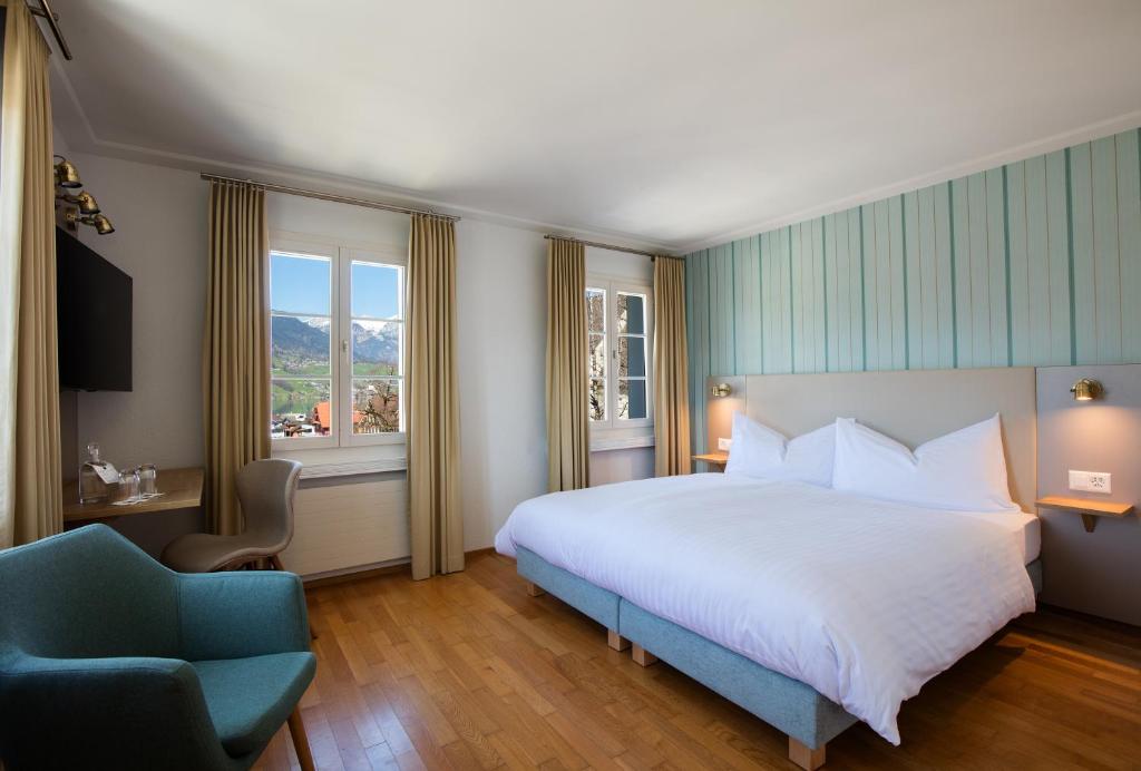 萨克瑟恩Hotel Kreuz by b-smart的一间卧室配有一张大床和一张蓝色椅子