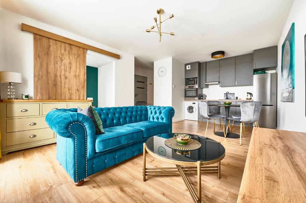 奥尔什丁Apartament Księżycowy的客厅配有蓝色的沙发和桌子