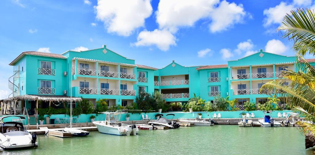 克拉伦代克Ocean Breeze Boutique Hotel & Marina的蓝色的建筑,船停靠在码头