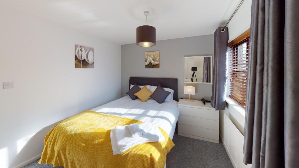 赫尔Marina House的一间卧室配有一张带黄色毯子和窗户的床