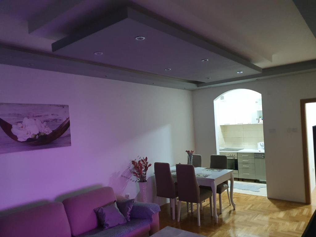 特雷比涅Oasis of Peace的客厅配有紫色沙发和桌子