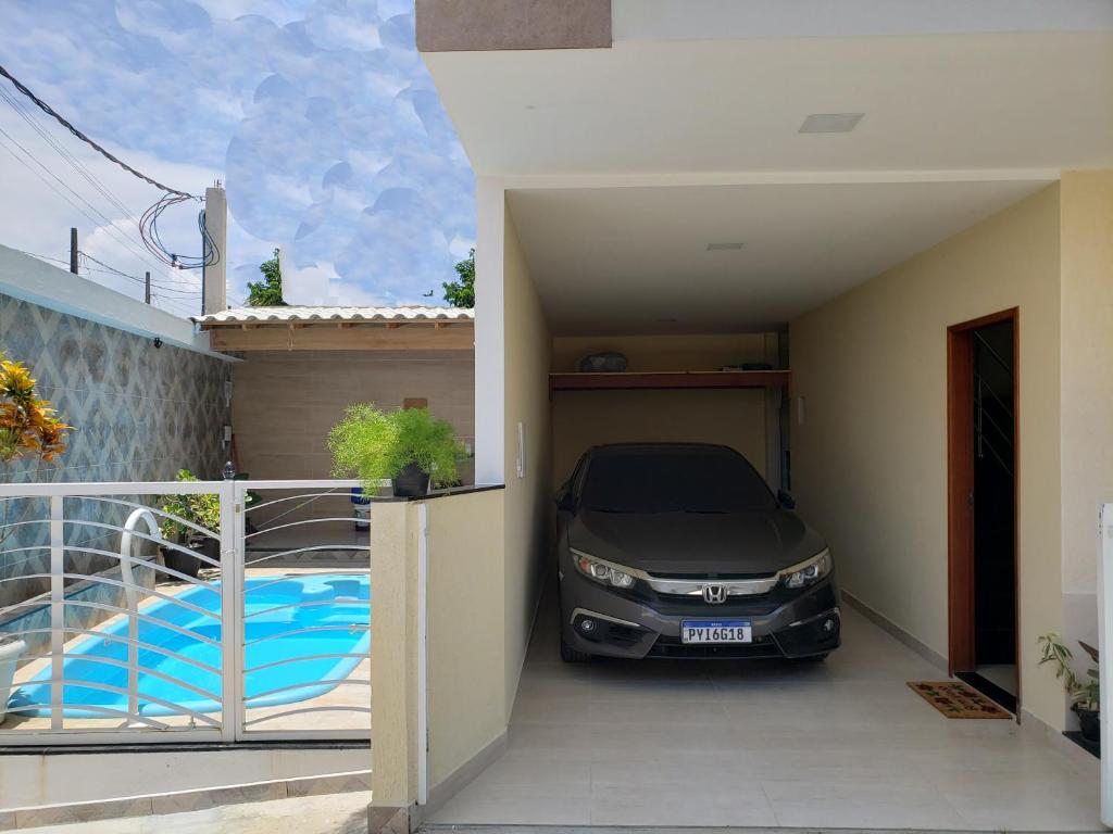 伊利利Casa Duplex Iriri - Banheira e Piscina的停在游泳池旁车库的汽车