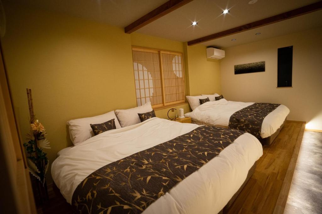 名古屋Ixyz別邸 月夜見の宿的一间客房内配有两张床的房间