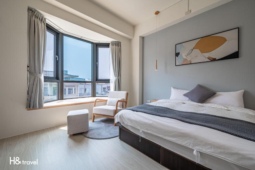 台东H& Taitung Feng Lin Resort Hotel的一间卧室配有一张床、一把椅子和窗户。