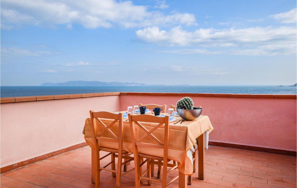 卡沃Pet Friendly Home In Cavo With House Sea View的俯瞰大海的阳台配有桌椅