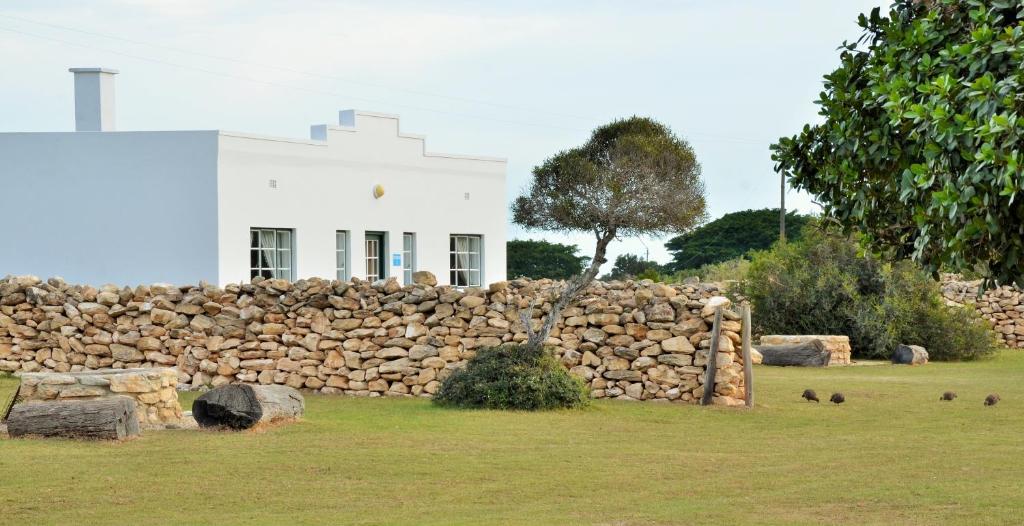 De Hoop Nature ReserveDe Hoop Collection - Equipped Cottages的白色建筑前的石墙