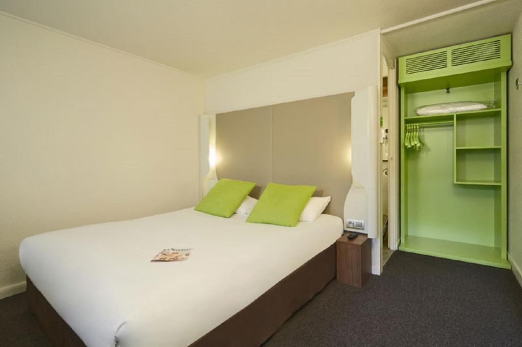 塞克兰里尔瑟克朗钟楼酒店的卧室配有带绿色枕头的大型白色床