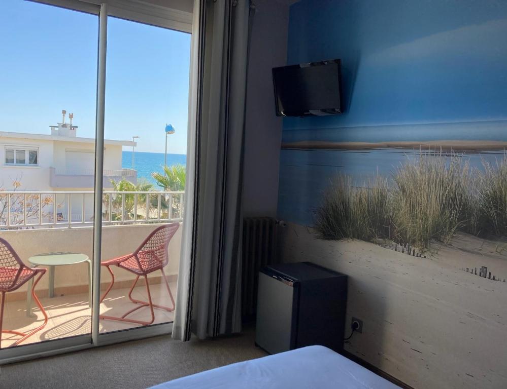 帕拉瓦莱弗洛迪米迪海滨酒店的一间卧室,享有带两把椅子的阳台的景色