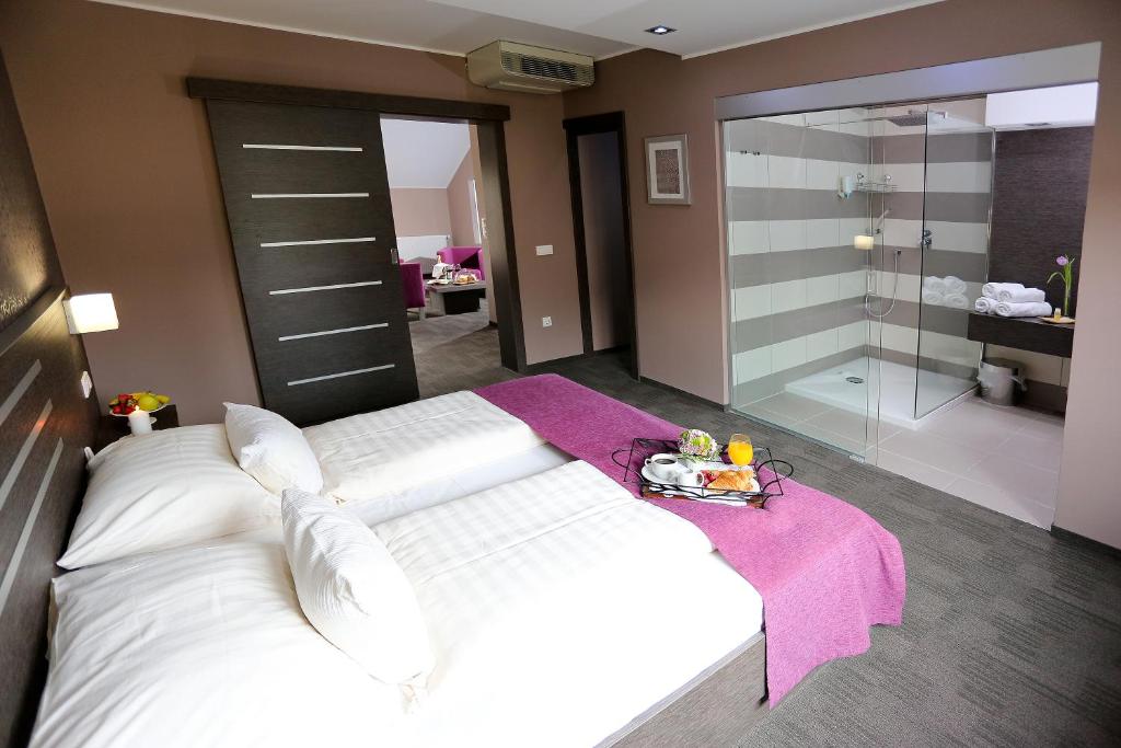 马里博尔Gostilna in motel Pri Lešniku的卧室配有一张白色大床和玻璃淋浴间