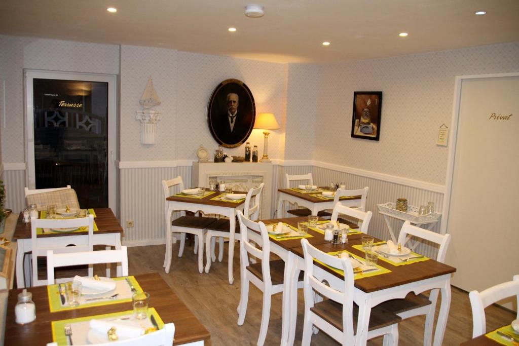 比苏姆祖尔布兰顿旅馆的用餐室配有白色的桌子和白色的椅子