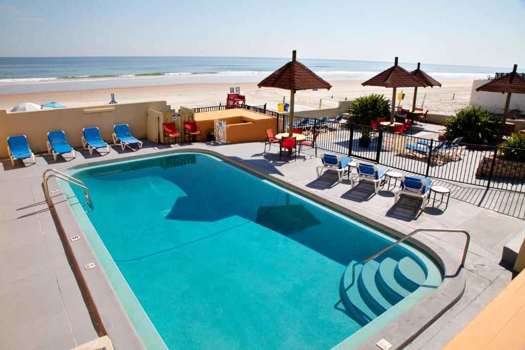 代托纳海滩Daytona Dream Inn By AmeriVu的一个带椅子的游泳池和海滩