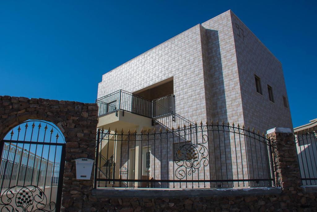 阿拉德Vastu Dead Sea apartment的前面有栅栏的建筑