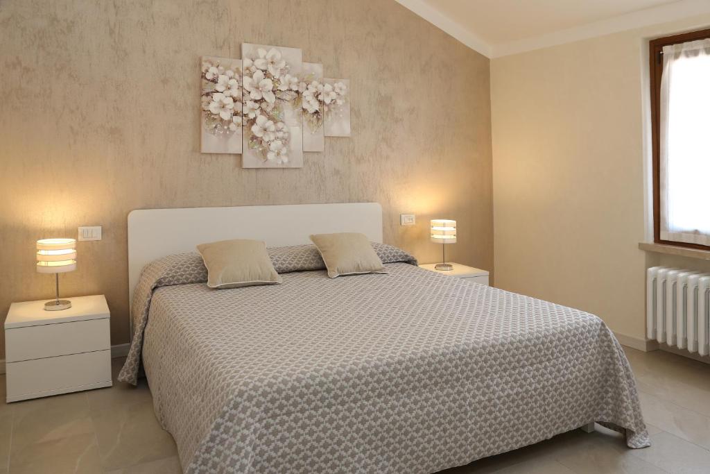 巴多利诺Flower Apartments的一间卧室配有一张带2个床头柜和2盏灯的床。
