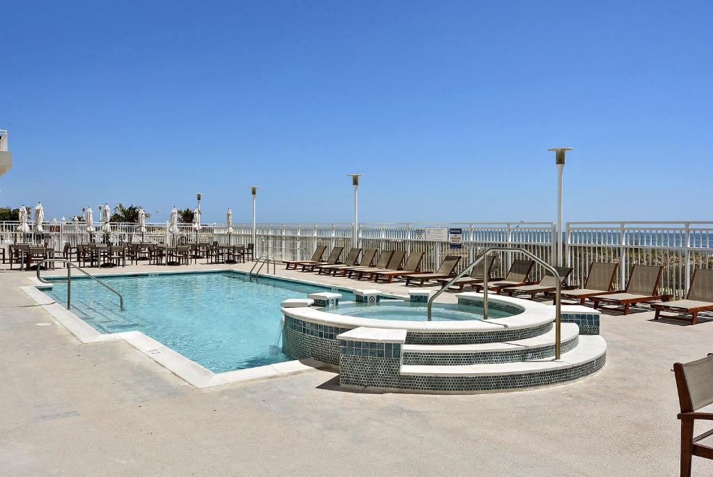 大洋城Gateway Grand的一个带椅子的游泳池和海滩