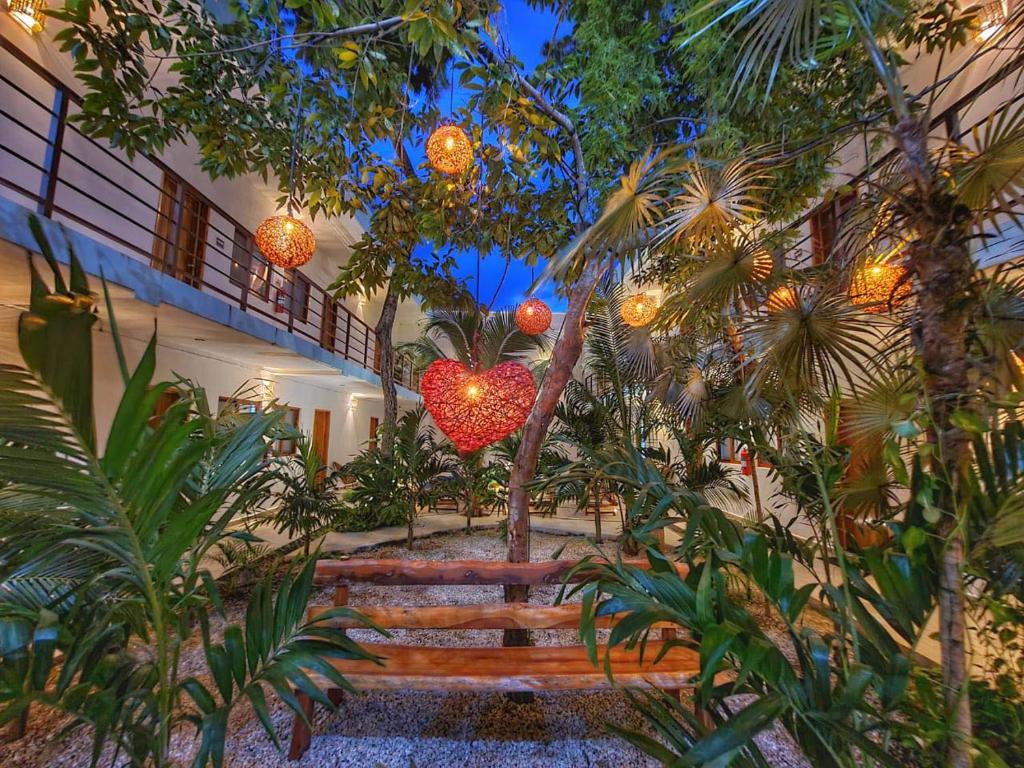 图卢姆Los Arcos Hotel - TULUM的一座花园,里面的心脏挂在一座建筑上