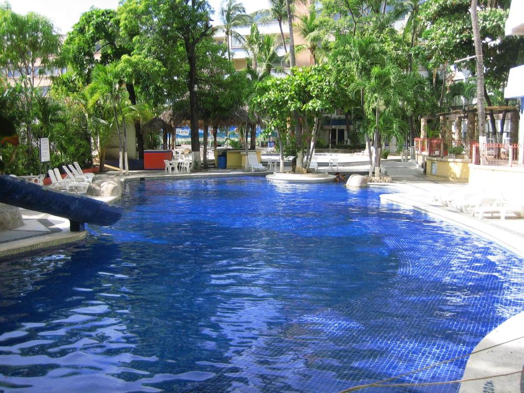 阿卡普尔科Hotel Delfines Acapulco by NG Hoteles的度假村内的一个蓝色海水游泳池