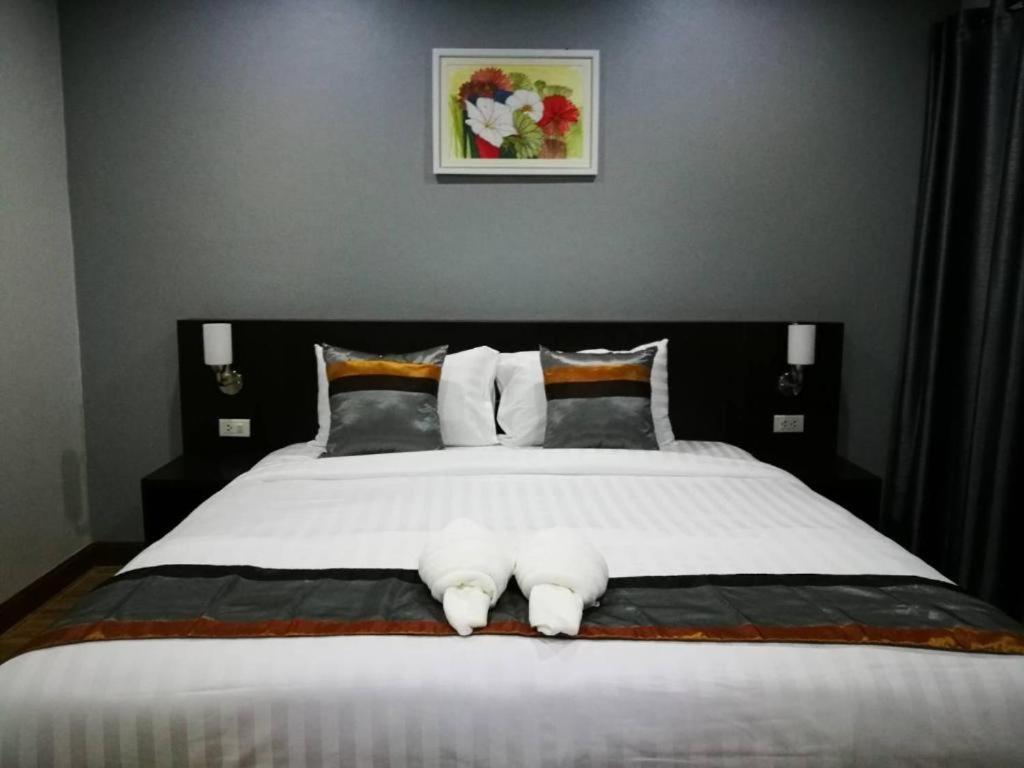 南府ช้างเผือกเกสต์เฮ้าส์的卧室配有一张带白色床单和枕头的大床。