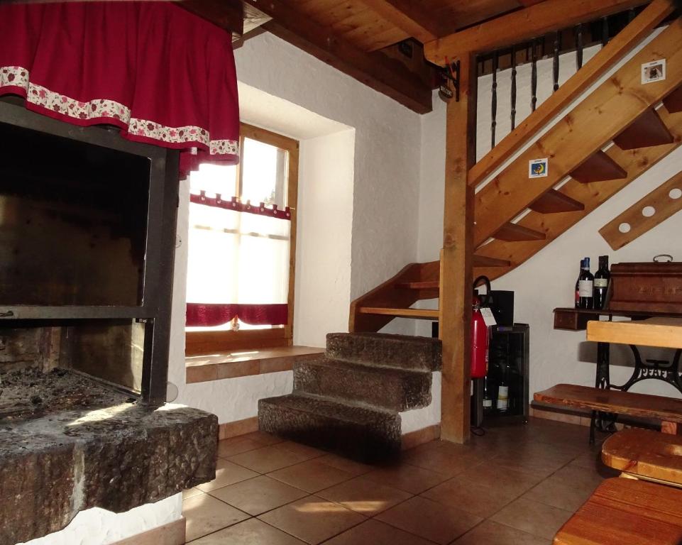 法尔西德Baita Casera Caviazza的一间带壁炉和楼梯的客厅