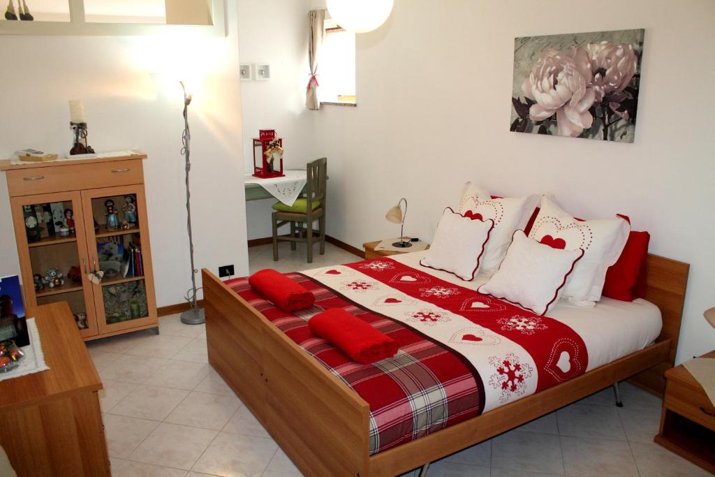 RoncegnoCasa Hueller的一间卧室配有红色和白色枕头的床