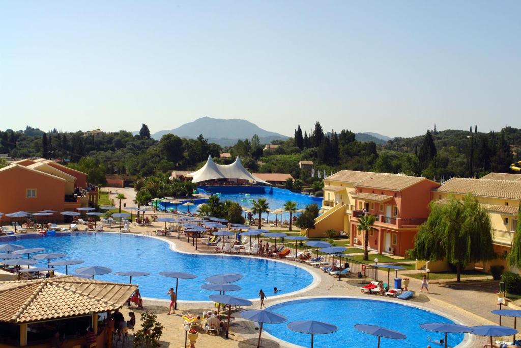 Ágios IoánnisAqualand Resort的一个带遮阳伞的大型游泳池的度假村