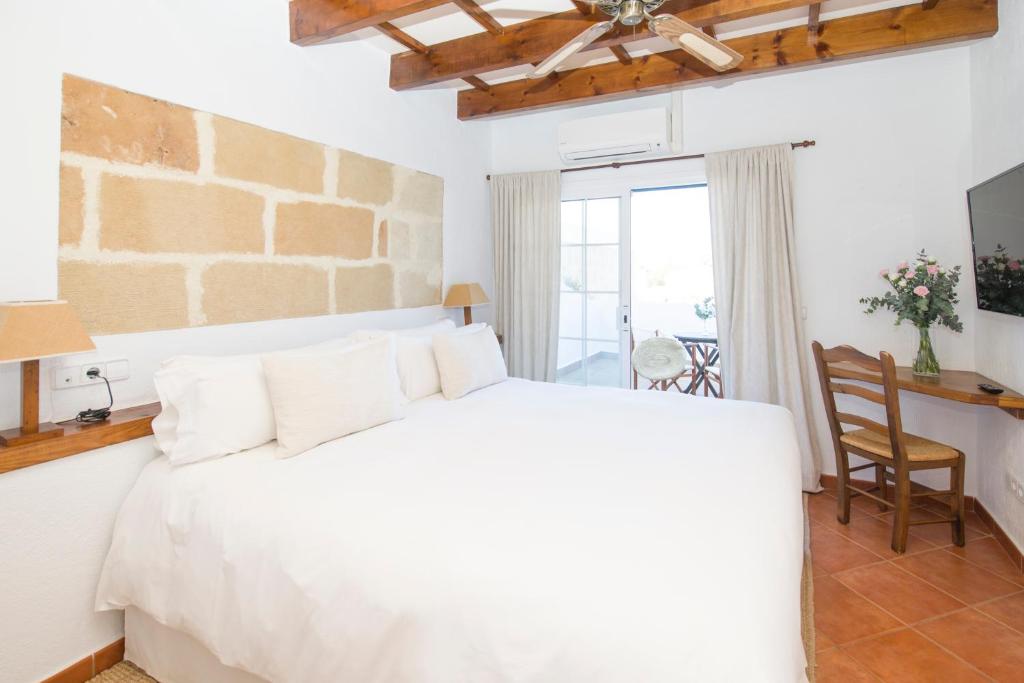 马翁尤可马桑尼斯大农场酒店的卧室配有白色的床、桌子和椅子