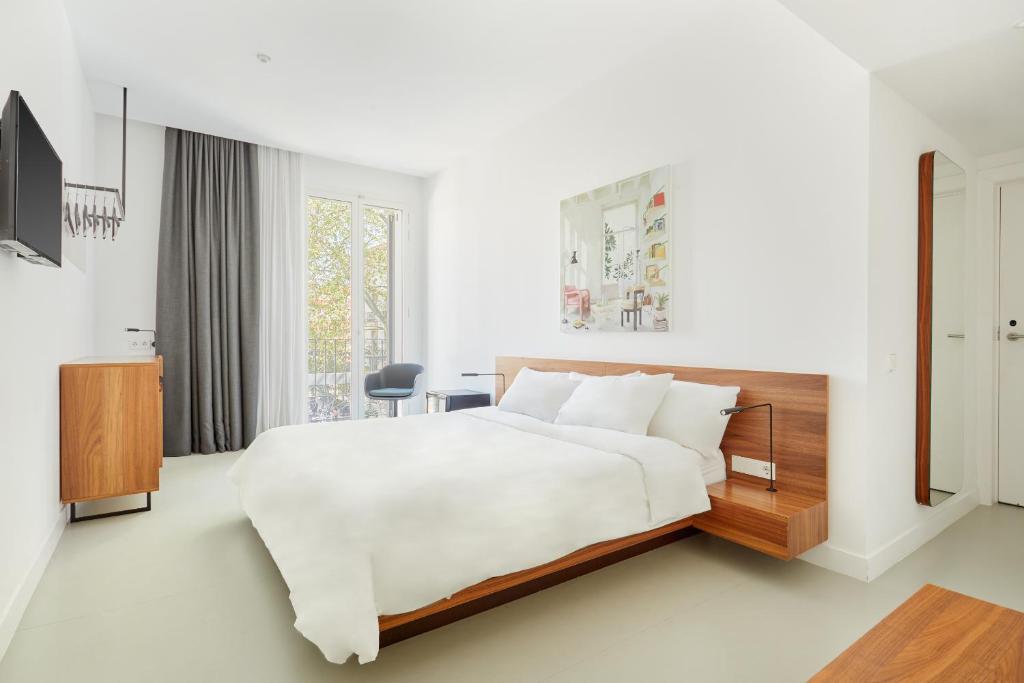 巴塞罗那Sonder La Casa del Sol的白色卧室设有一张大床和电视。