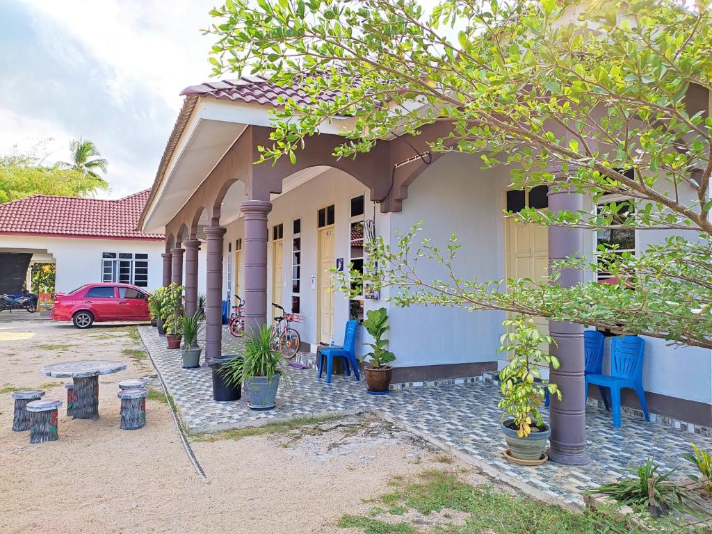 瓜拉勿述Desa Besut Inn的一座带门廊和红色停车场的房子