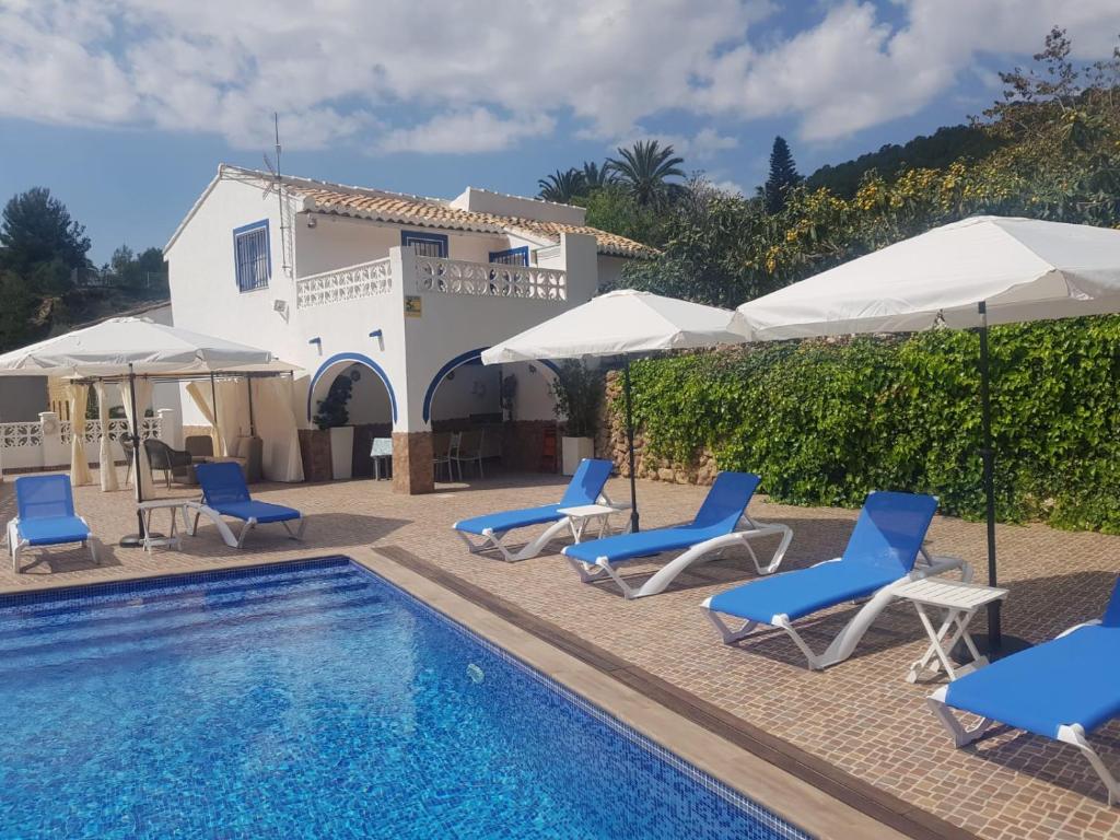 卡略萨登萨里亚A867 - La Rodeta的房屋旁的游泳池配有椅子和遮阳伞