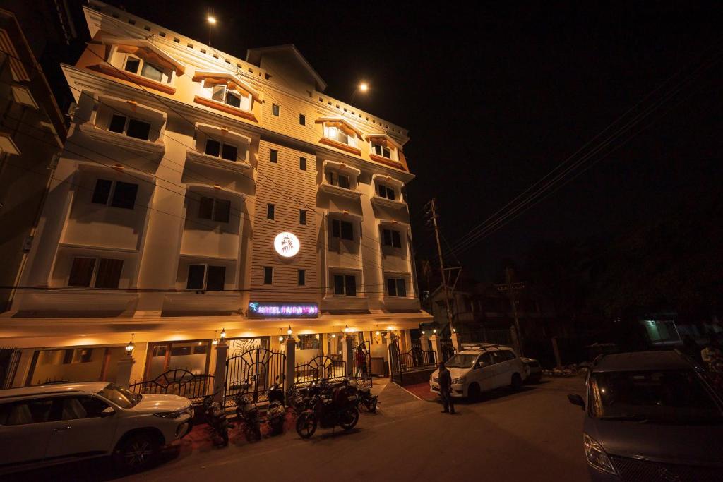 西里古里Rajdarbar Hotel & Banquet, Siliguri的一座建筑,晚上停在前面