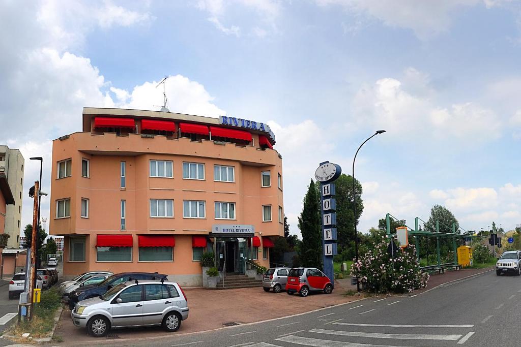 塞格拉泰里维耶拉酒店的停车场内有车辆的建筑物