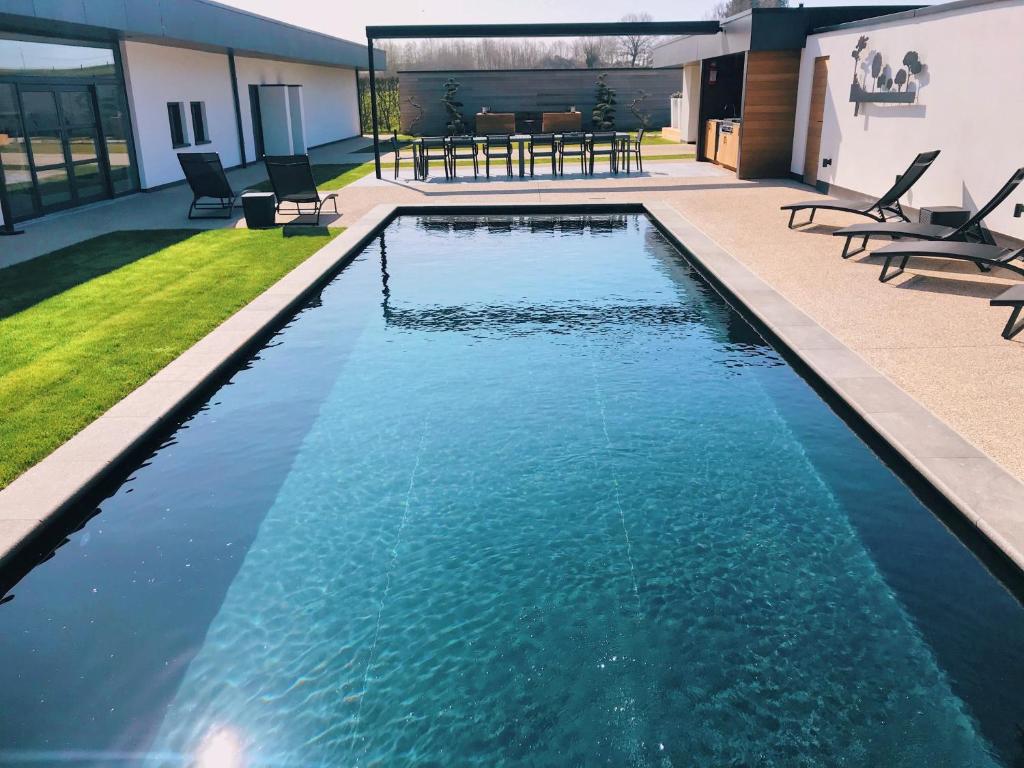 伊普尔5-sterren Landhuis met zwembad en jacuzzi的后院的蓝色海水游泳池