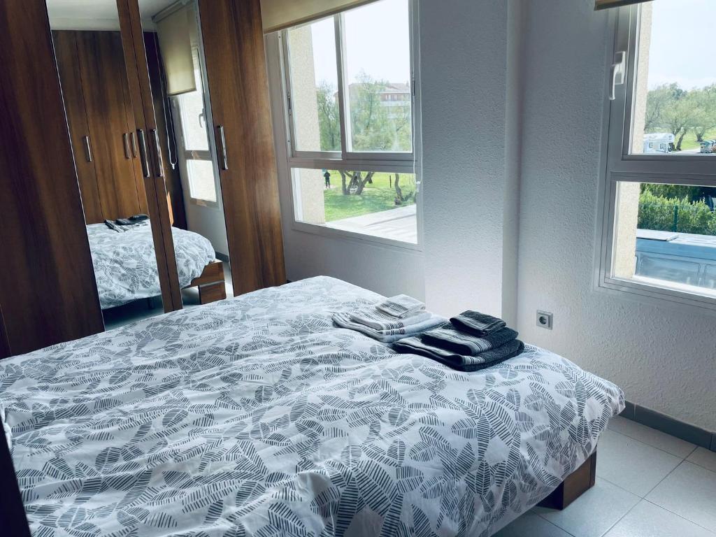 埃斯塔蒂特APARTAMENT ILLA MAR D´OR L`ESTARTIT的卧室配有一张带白色棉被和窗户的床