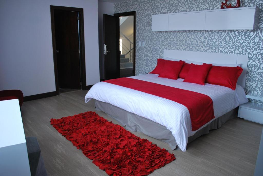 昆卡利奥尼精品酒店的一间卧室配有一张带红色枕头的大床