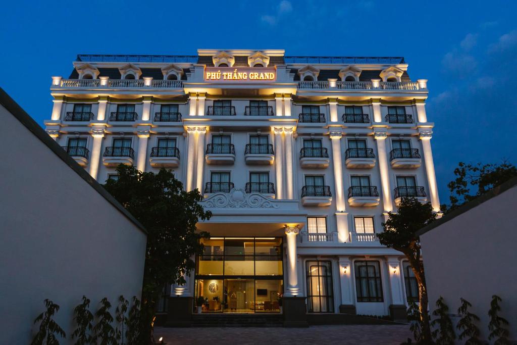 Ðức HòaPHU THANG GRAND HOTEL的一座白色的大建筑,上面有标志